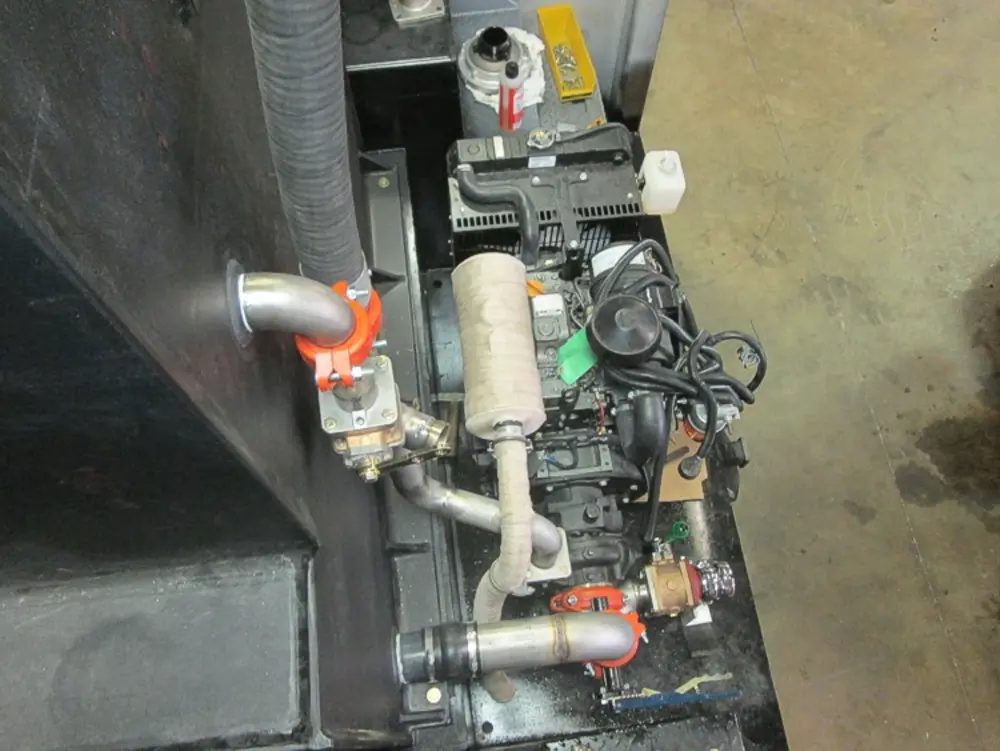 Exterior view of small fire truck showing cab, body compartments, and wheel/tire area.