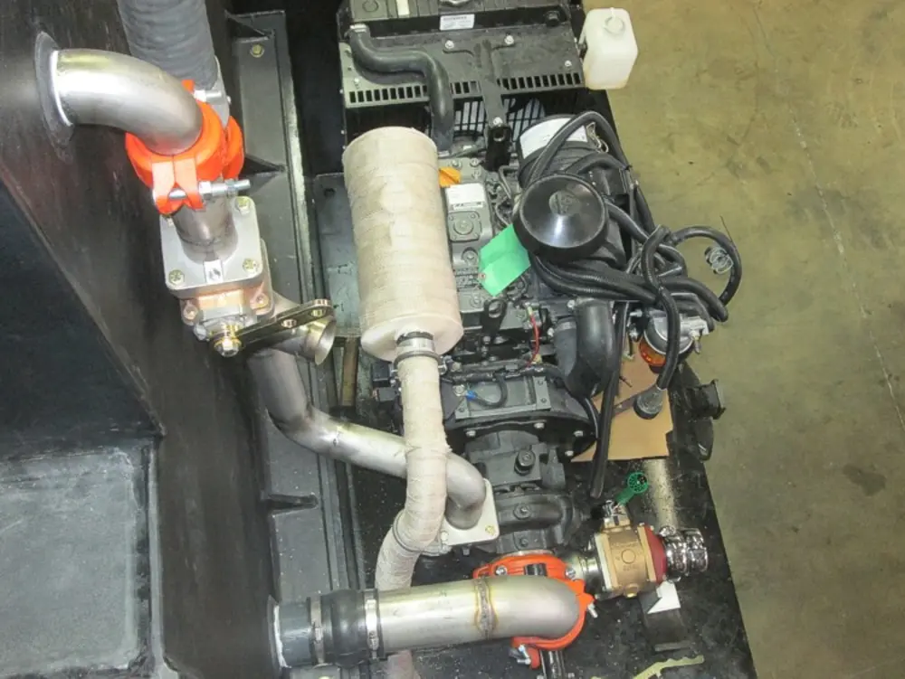 Exterior view of small fire truck showing cab, body compartments, and wheel/tire area.