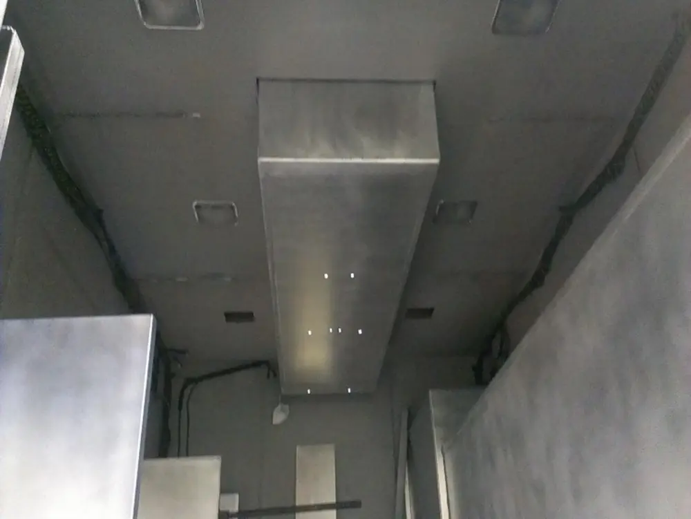 Exterior view of small fire truck showing cab, body compartments, and wheel/tire area.