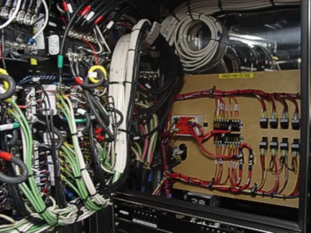 Exterior view of small fire truck showing cab, body compartments, and wheel/tire area.