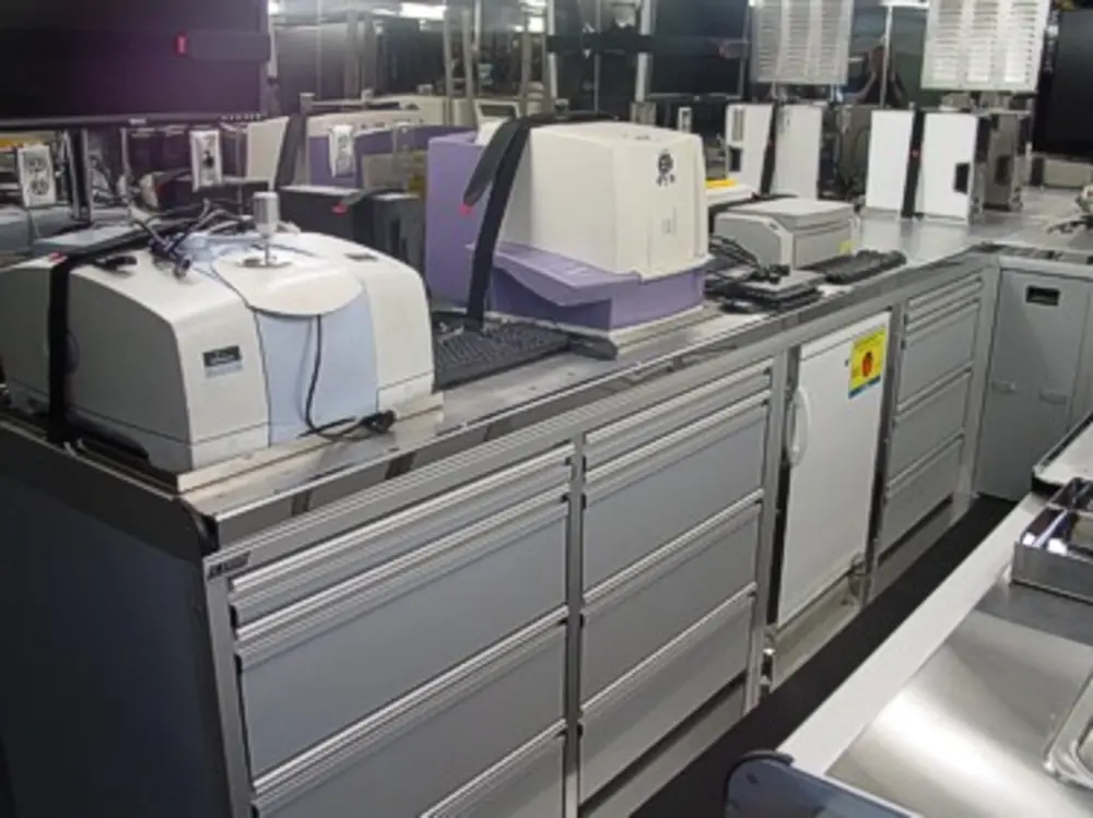 Exterior view of small fire truck showing cab, body compartments, and wheel/tire area.