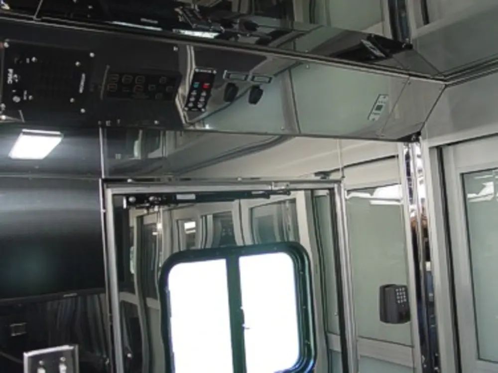 Exterior view of small fire truck showing cab, body compartments, and wheel/tire area.