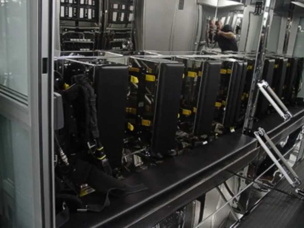 Exterior view of small fire truck showing cab, body compartments, and wheel/tire area.