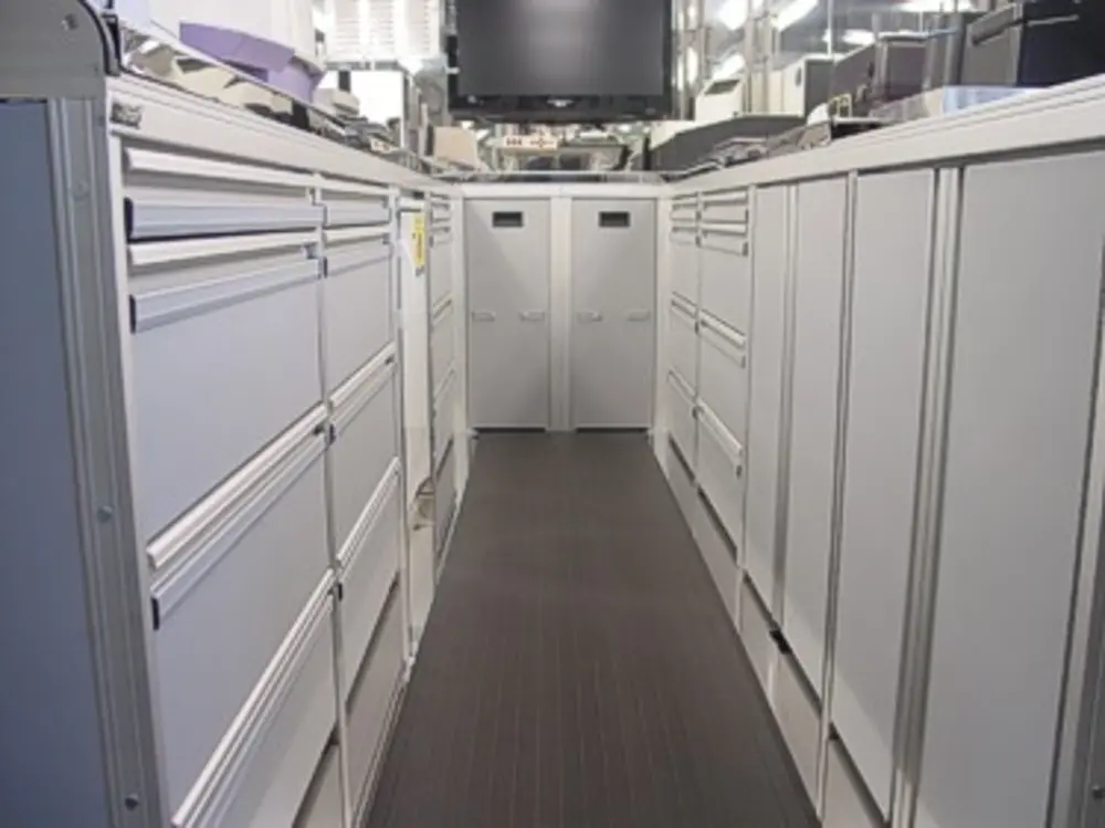 Exterior view of small fire truck showing cab, body compartments, and wheel/tire area.