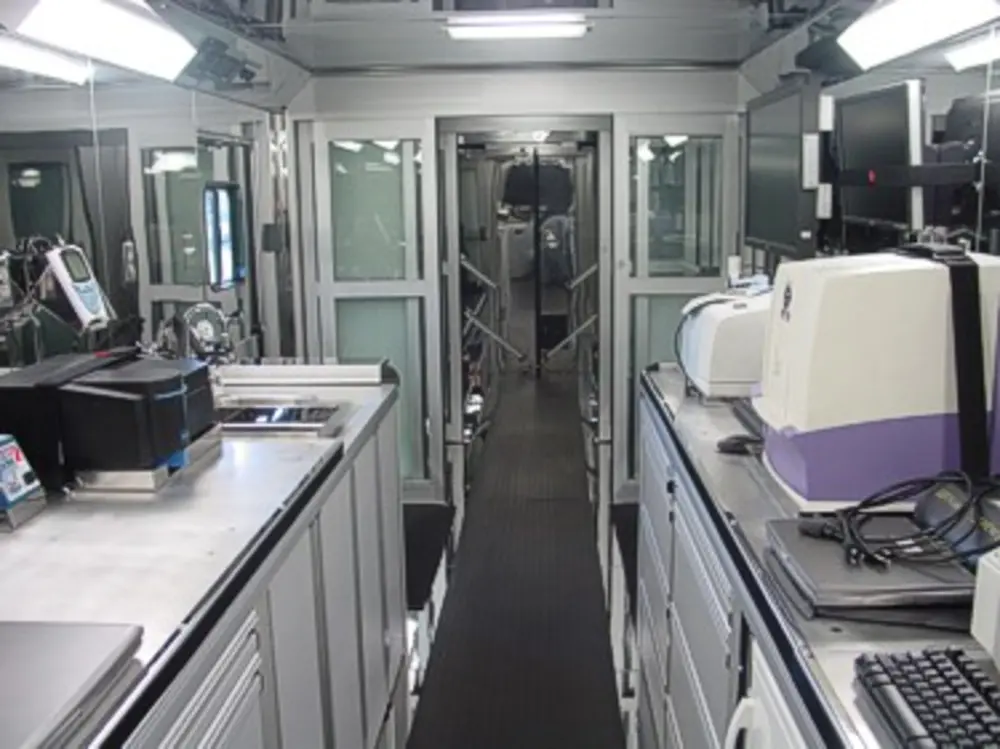 Exterior view of small fire truck showing cab, body compartments, and wheel/tire area.