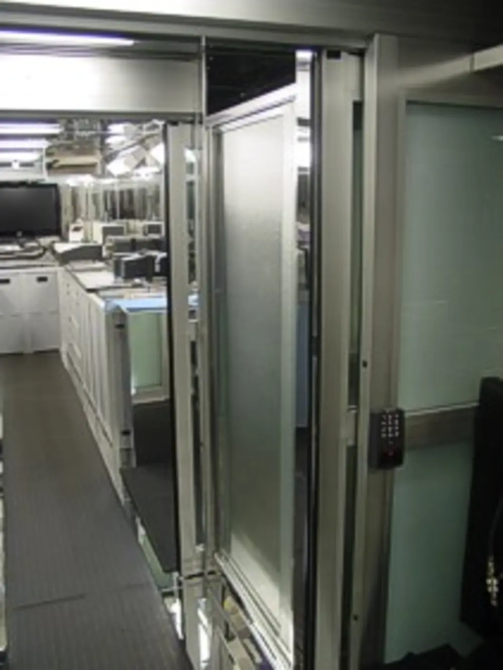 Exterior view of small fire truck showing cab, body compartments, and wheel/tire area.