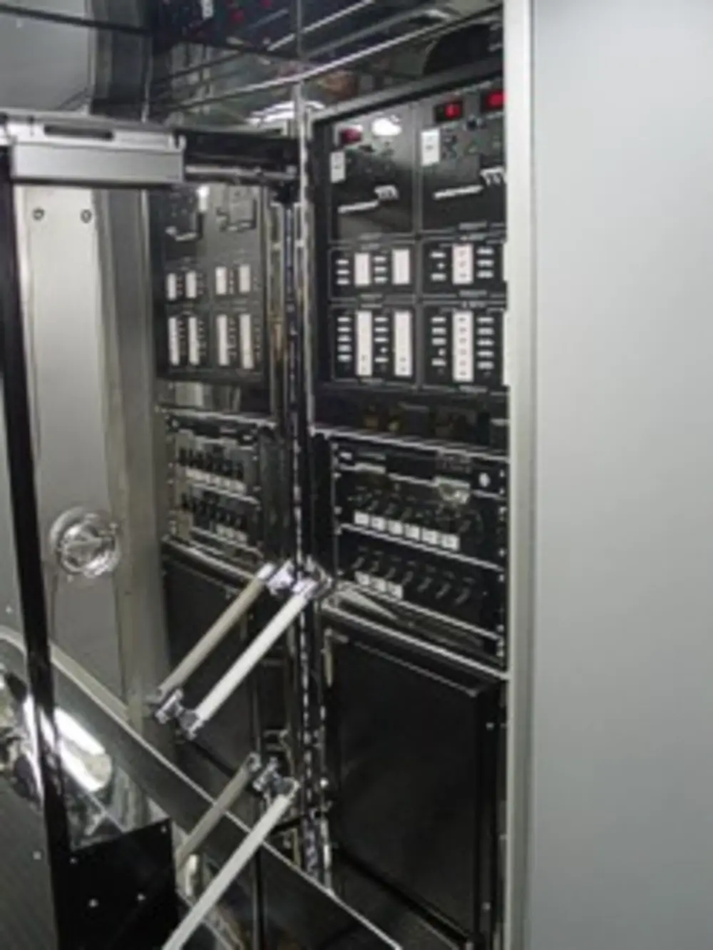 Exterior view of small fire truck showing cab, body compartments, and wheel/tire area.