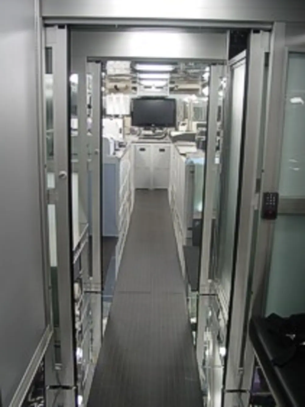 Exterior view of small fire truck showing cab, body compartments, and wheel/tire area.