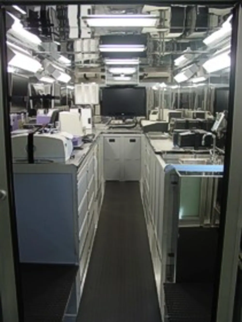 Exterior view of small fire truck showing cab, body compartments, and wheel/tire area.