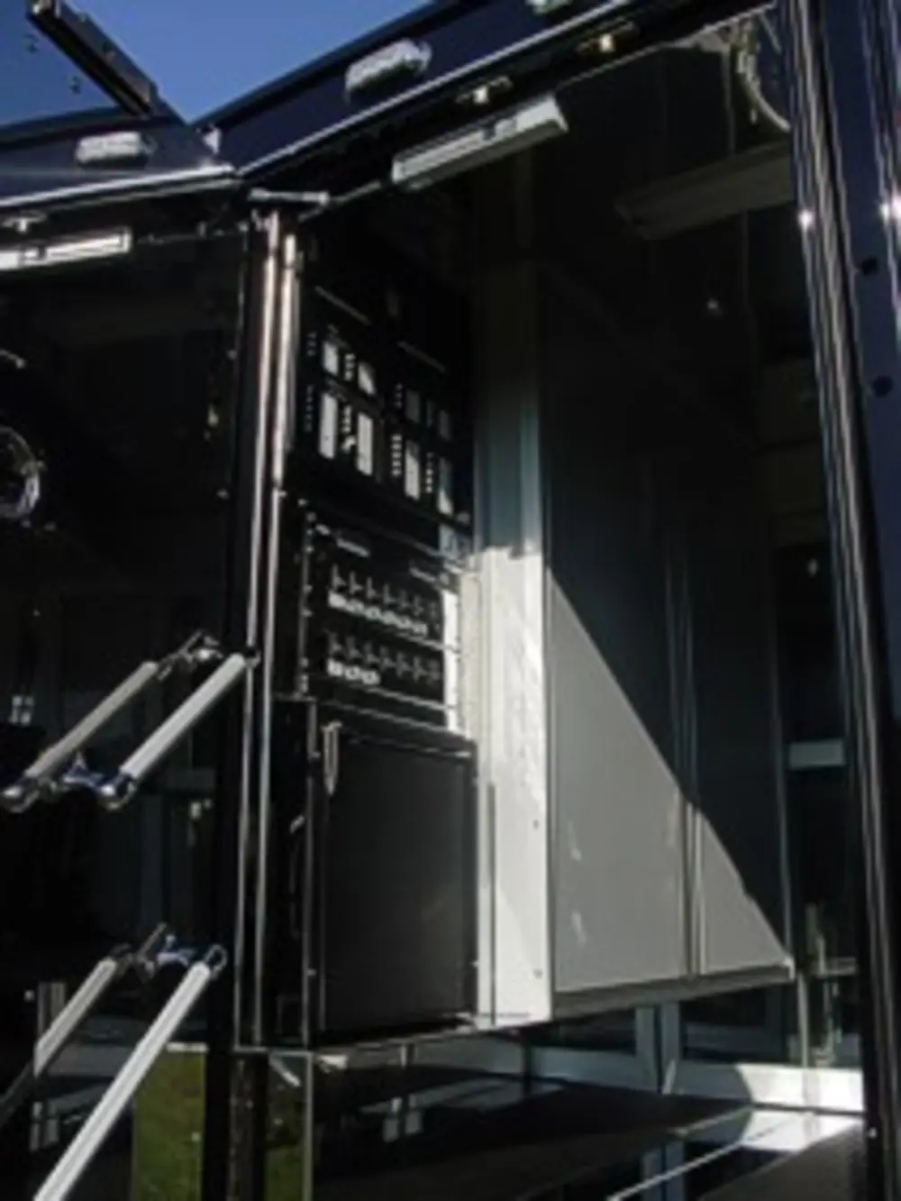 Exterior view of small fire truck showing cab, body compartments, and wheel/tire area.