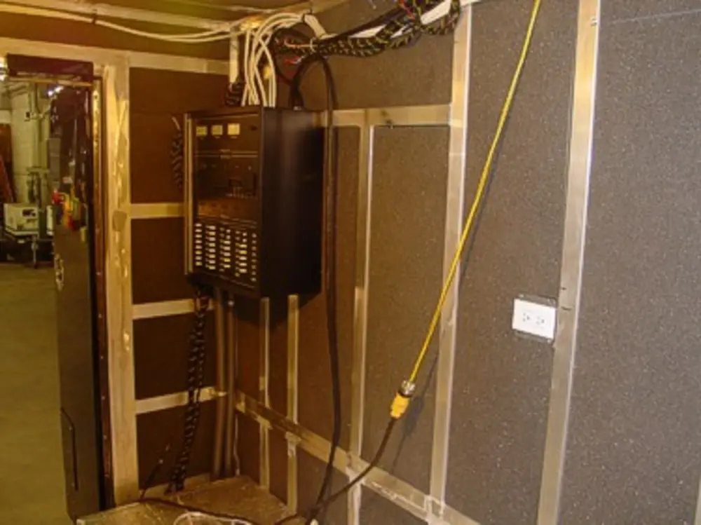 Exterior view of small fire truck showing cab, body compartments, and wheel/tire area.