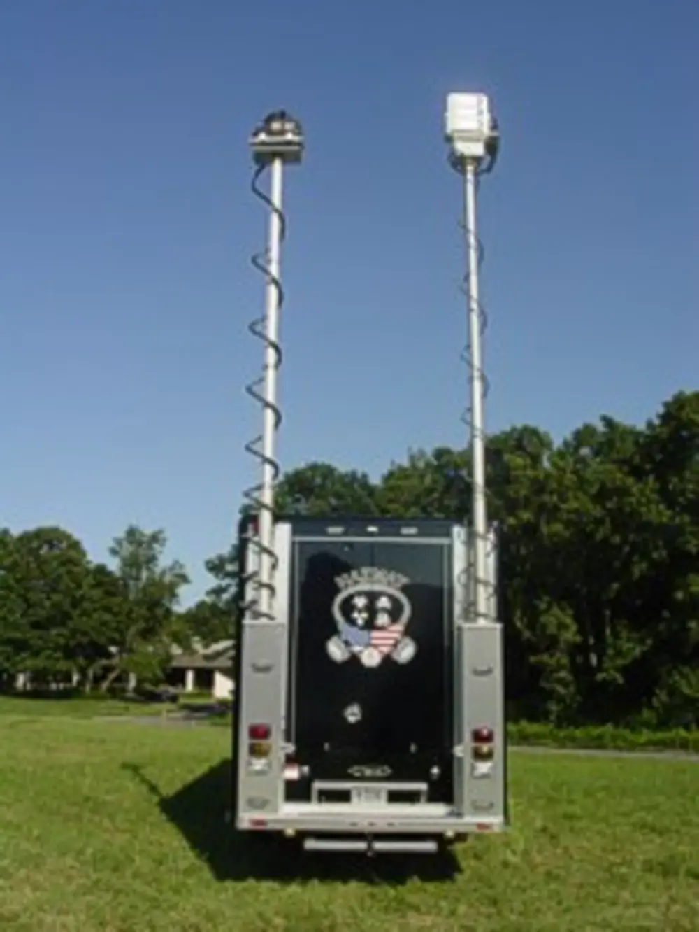 Exterior view of small fire truck showing cab, body compartments, and wheel/tire area.