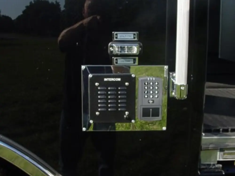 Exterior view of small fire truck showing cab, body compartments, and wheel/tire area.