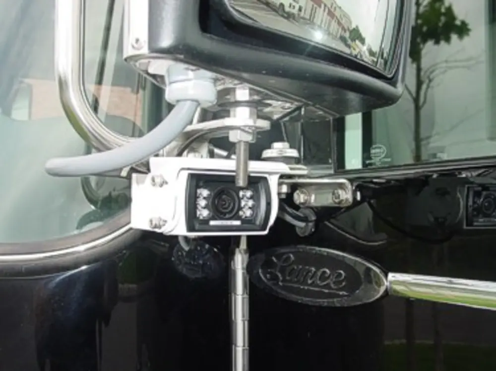 Exterior view of small fire truck showing cab, body compartments, and wheel/tire area.