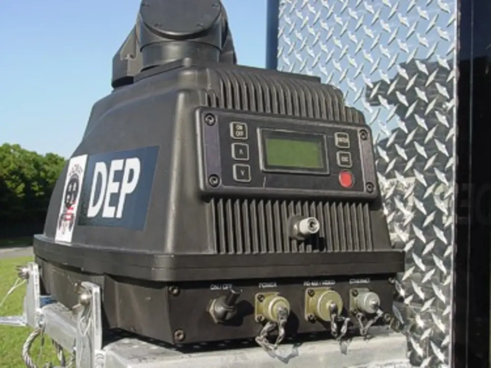 Exterior view of small fire truck showing cab, body compartments, and wheel/tire area.