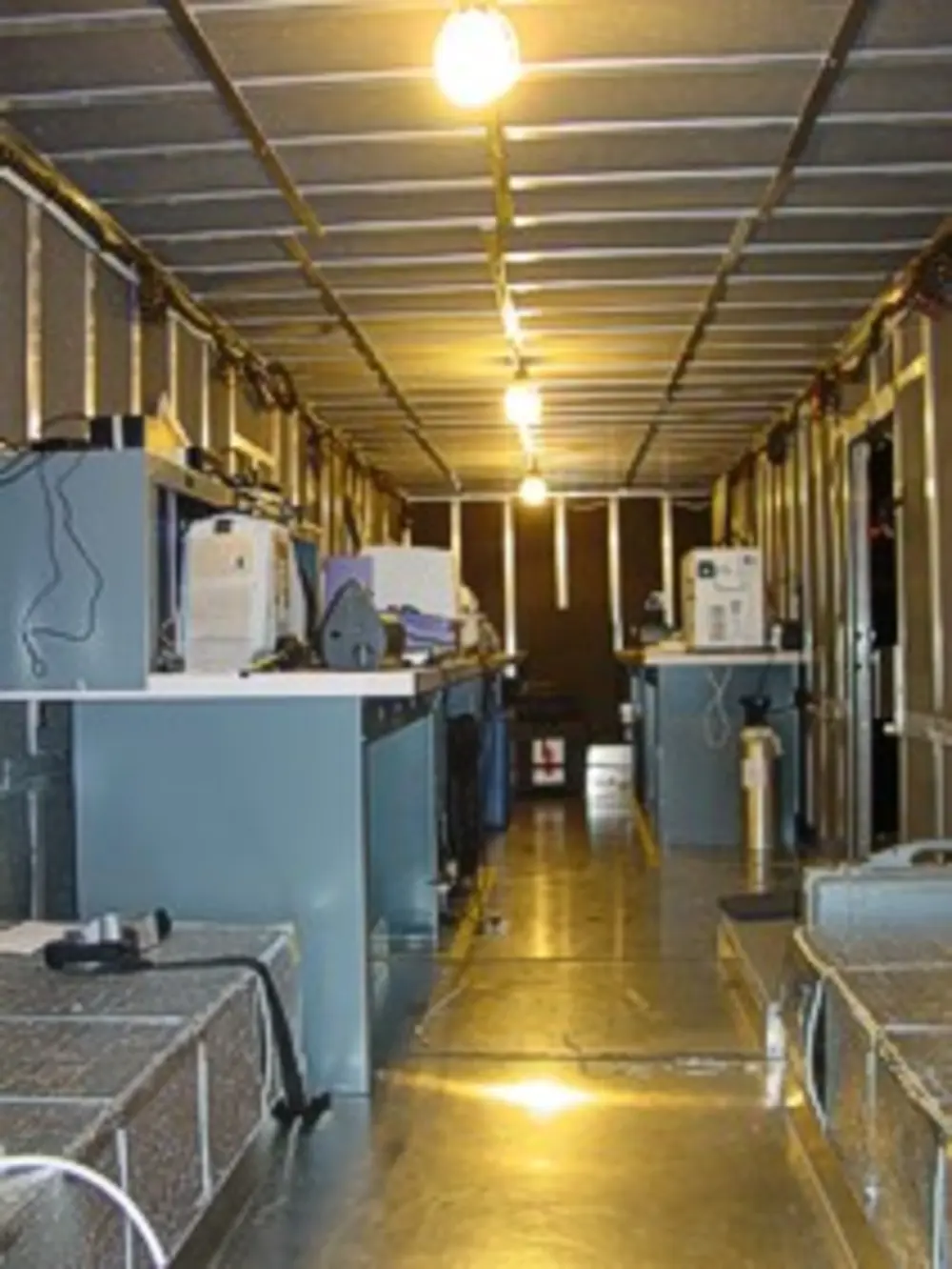 Exterior view of small fire truck showing cab, body compartments, and wheel/tire area.