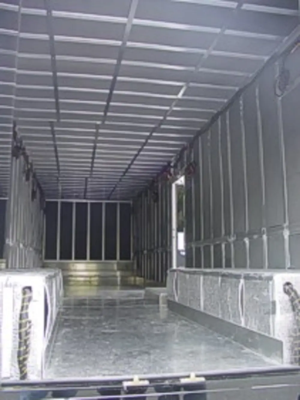 Exterior view of small fire truck showing cab, body compartments, and wheel/tire area.