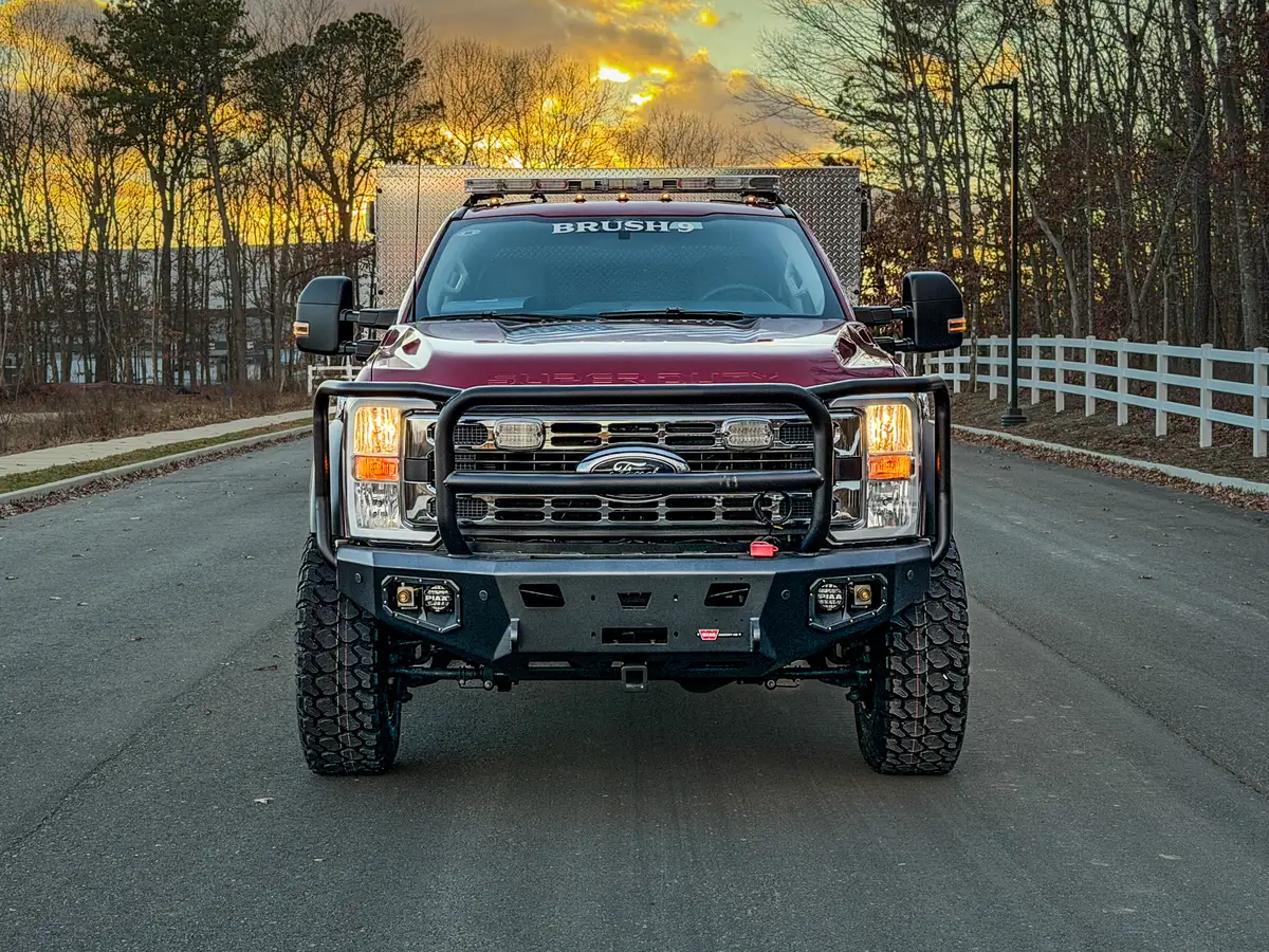 Head-on front view with grille guard and heavy-duty bumper.