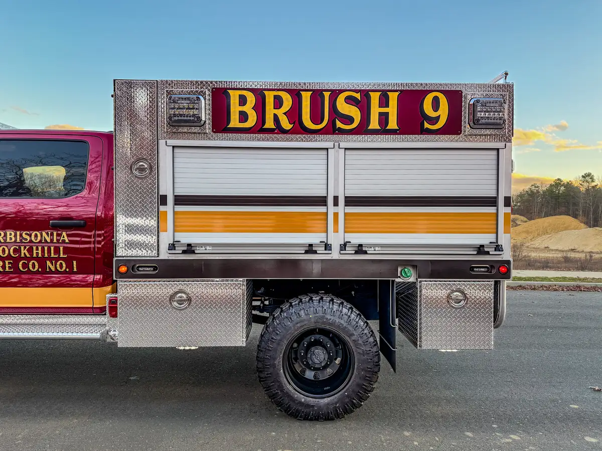 Mid-body side view with BRUSH 9 lettering above roll-up doors.