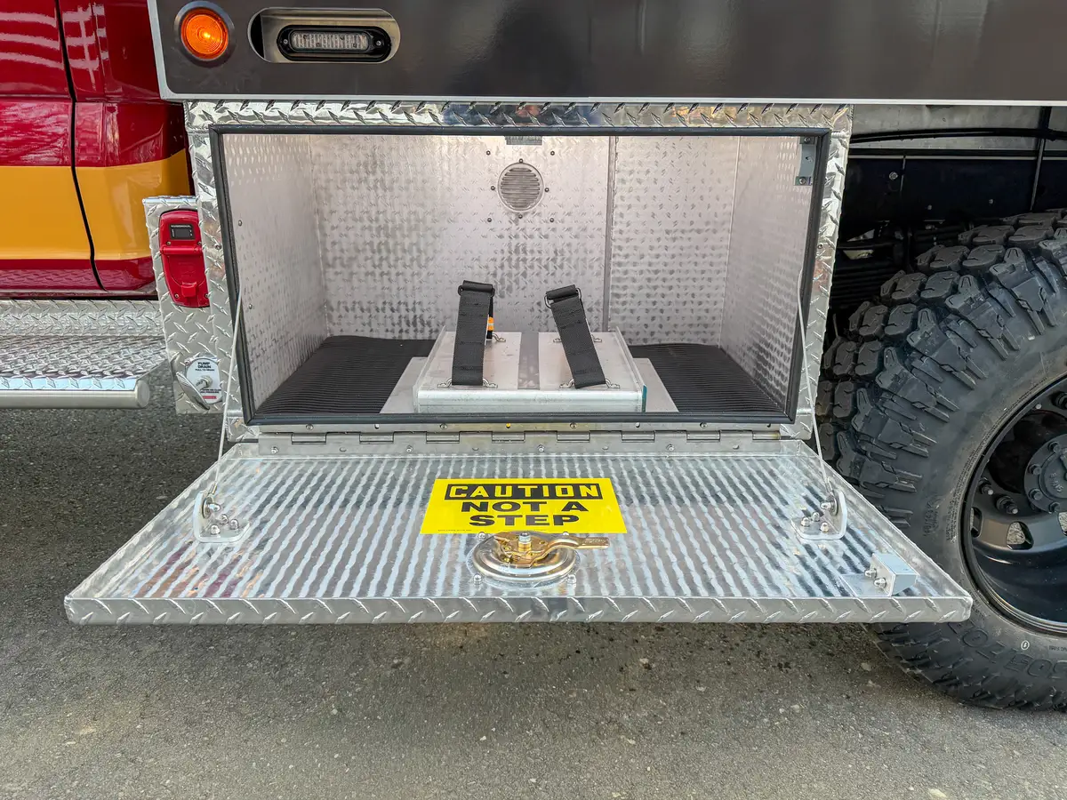 Open lower rear-side compartment with mounted brackets.