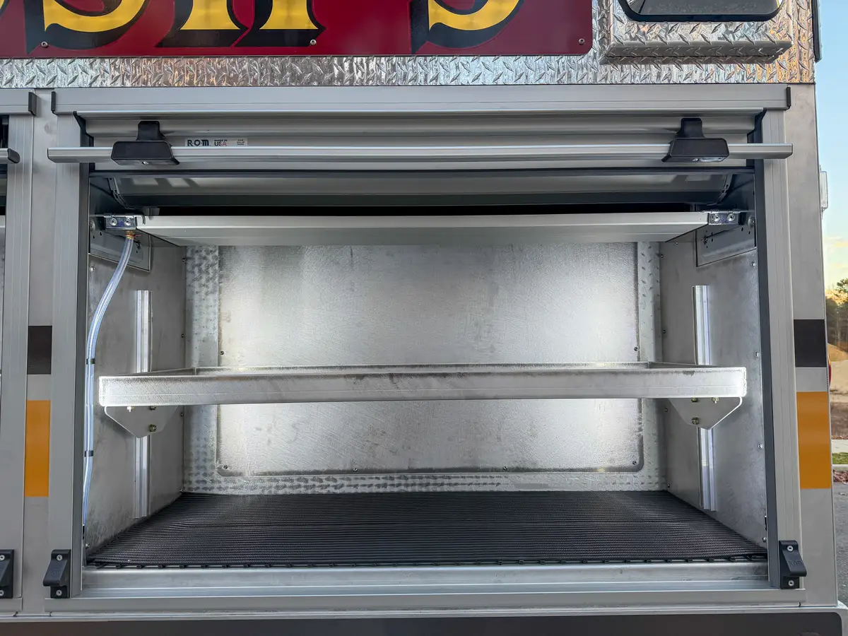 Open side compartment with two shelves and rubber floor mat.