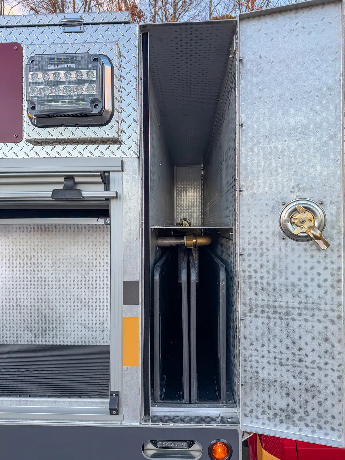 Narrow side compartment with mounted cylinder and latch hardware.