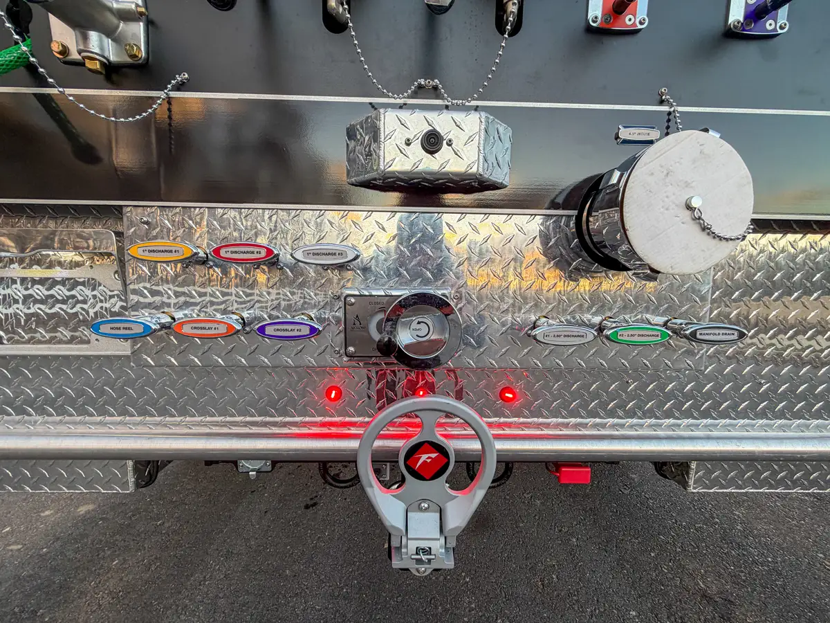 Rear underbody plumbing, hitch ring, and valve assembly close-up.