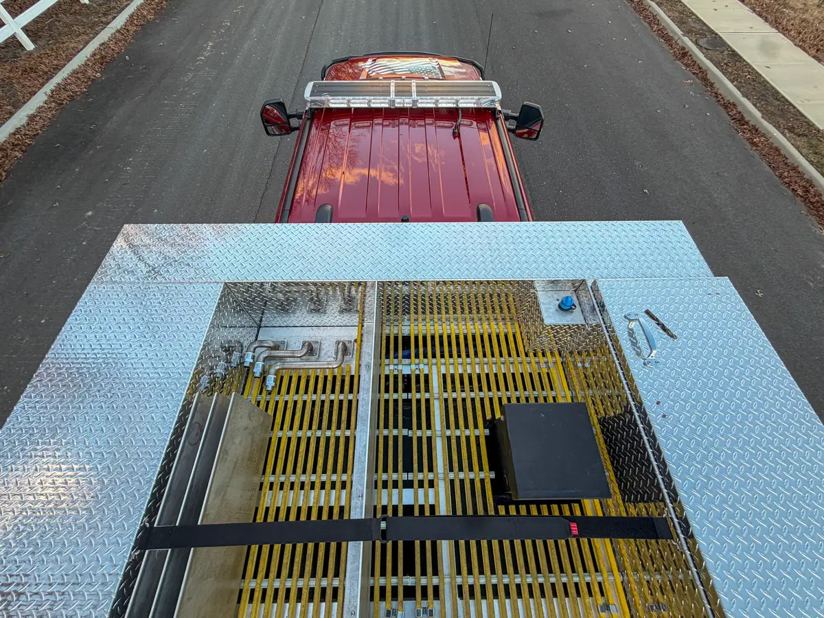 Upper deck with yellow grating and side rails toward cab.