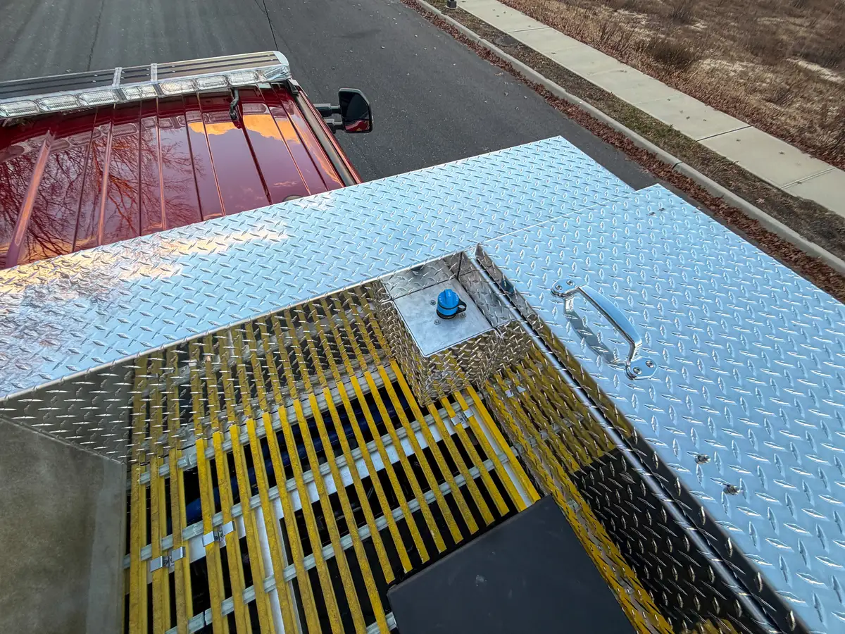 Top deck corner showing grating, railings, and panel hardware.