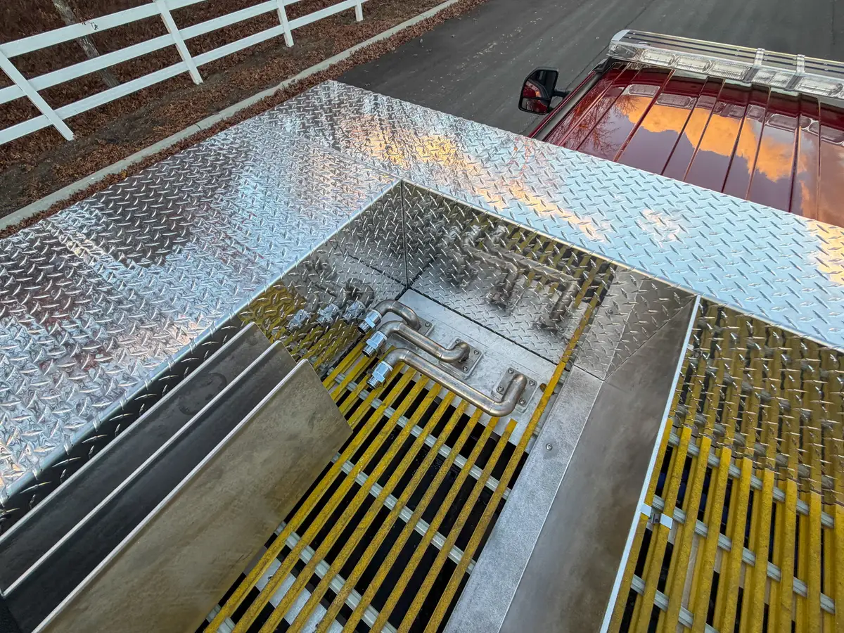 Open top compartment with yellow grated floor section.
