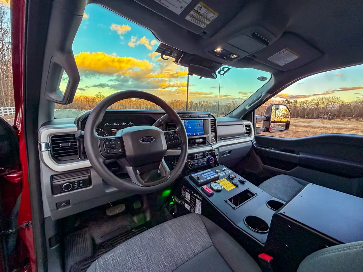 Driver cockpit with steering wheel and console controls.