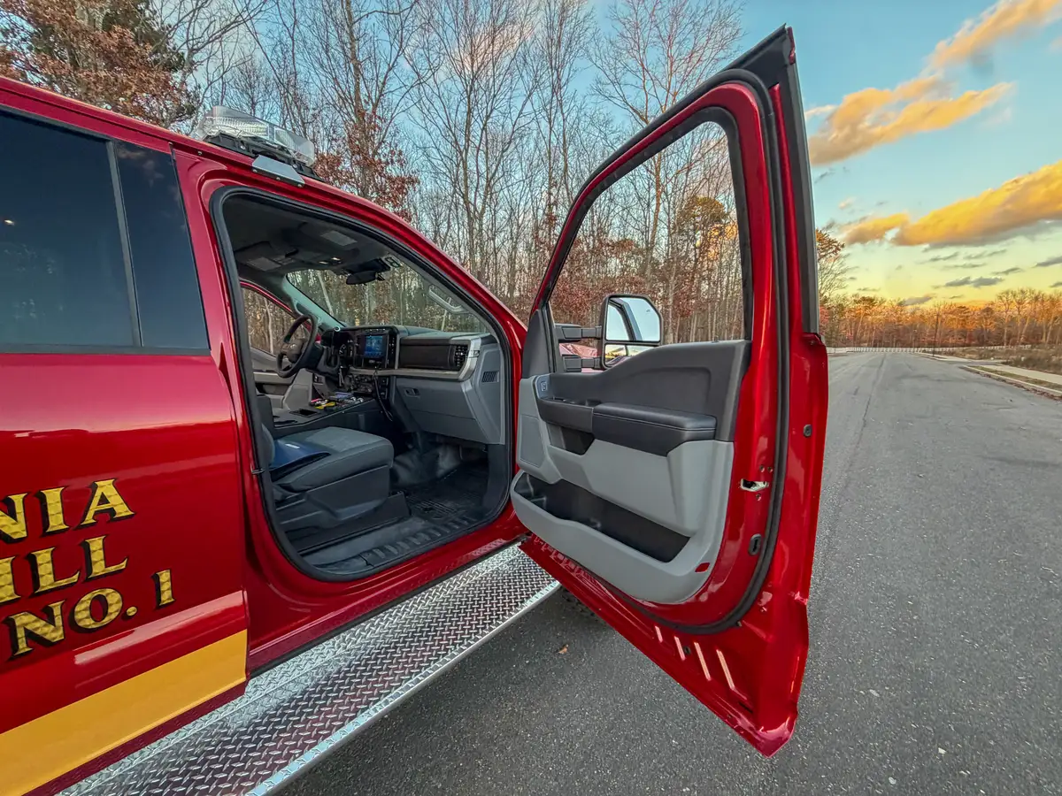 Open front driver door with step and seat visible.