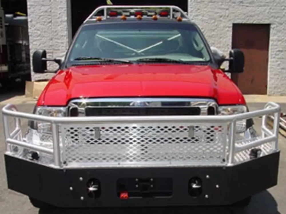 Exterior view of small fire truck showing cab, body compartments, and wheel/tire area.