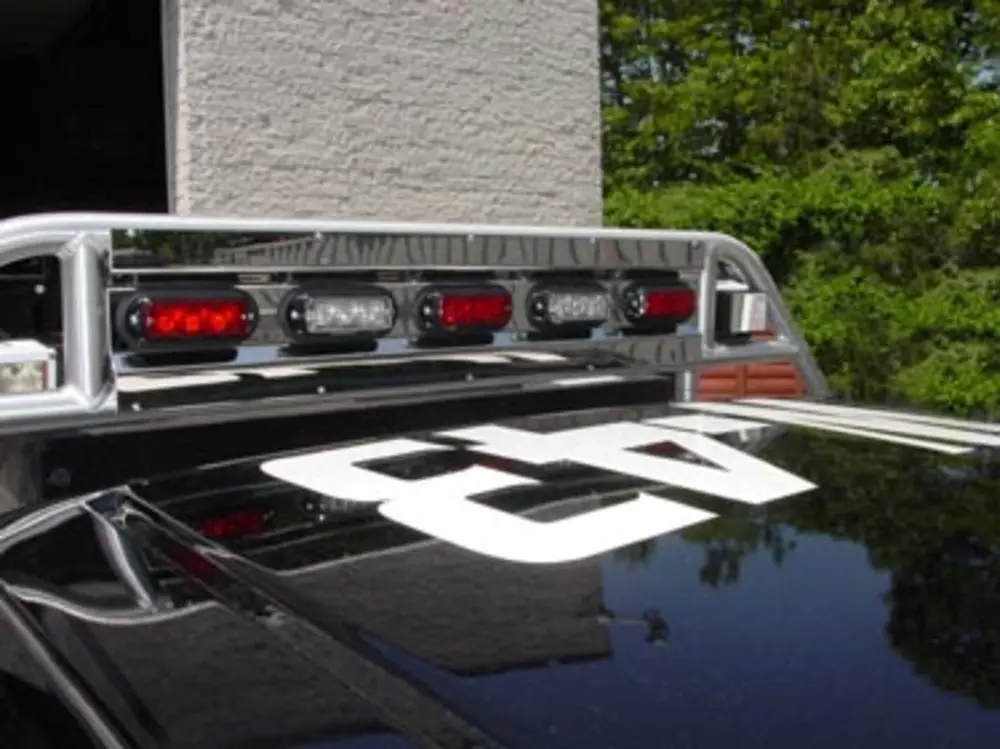 Exterior view of small fire truck showing cab, body compartments, and wheel/tire area.