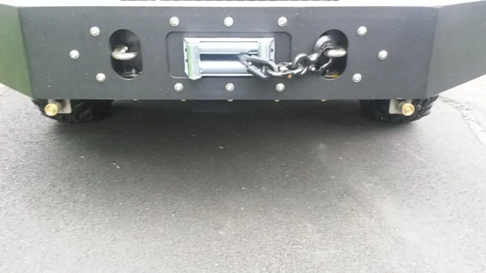 Exterior view of small fire truck showing cab, body compartments, and wheel/tire area.