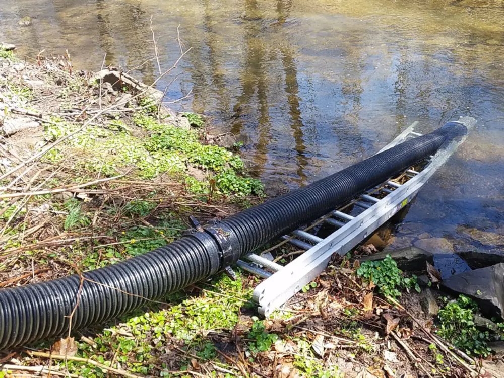 Exterior view of small fire truck showing cab, body compartments, and wheel/tire area.