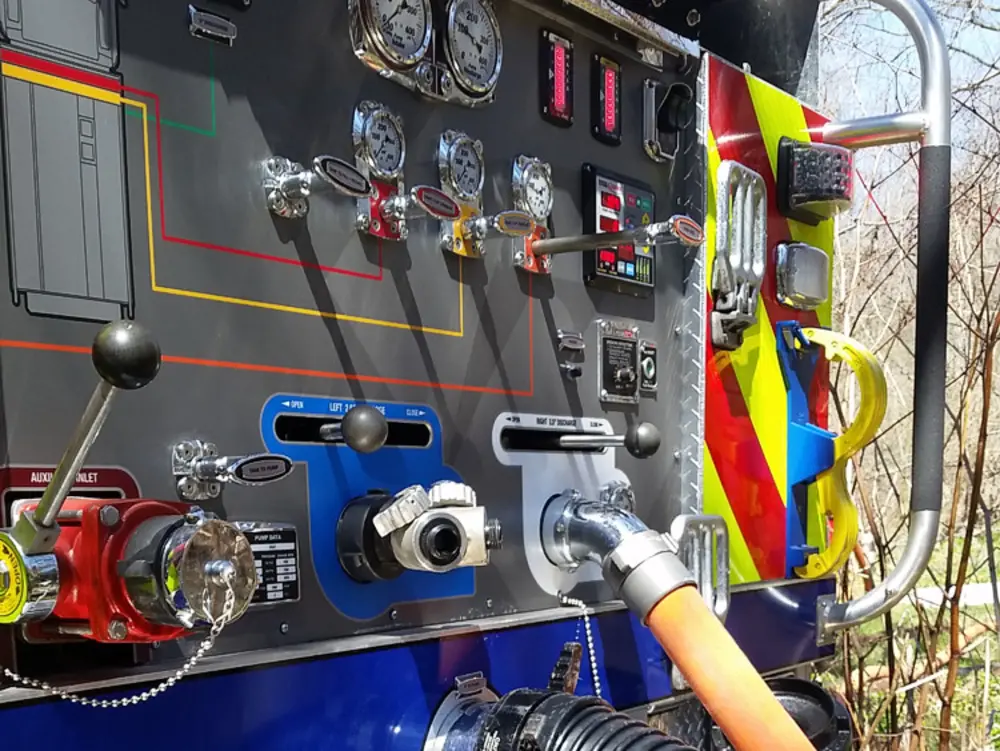 Exterior view of small fire truck showing cab, body compartments, and wheel/tire area.