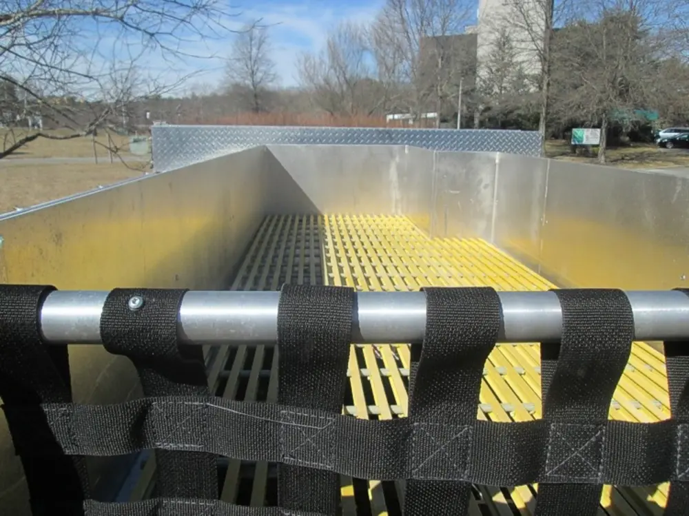 Exterior view of small fire truck showing cab, body compartments, and wheel/tire area.