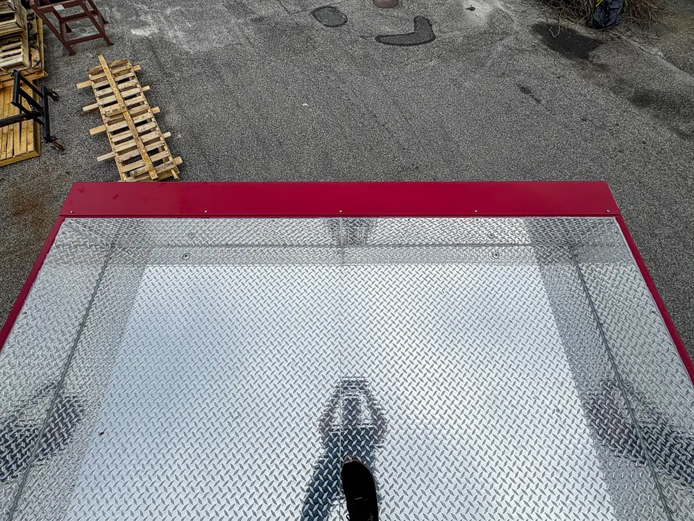 Exterior view of small fire truck showing cab, body compartments, and wheel/tire area.