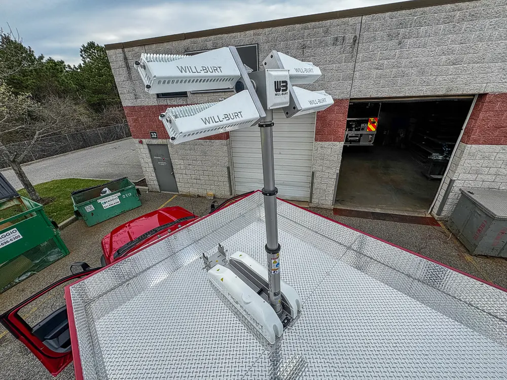 Exterior view of small fire truck showing cab, body compartments, and wheel/tire area.