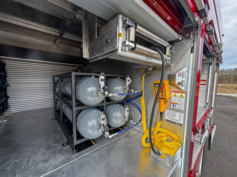 Close view of air cylinder rack and yellow wired control pendant.