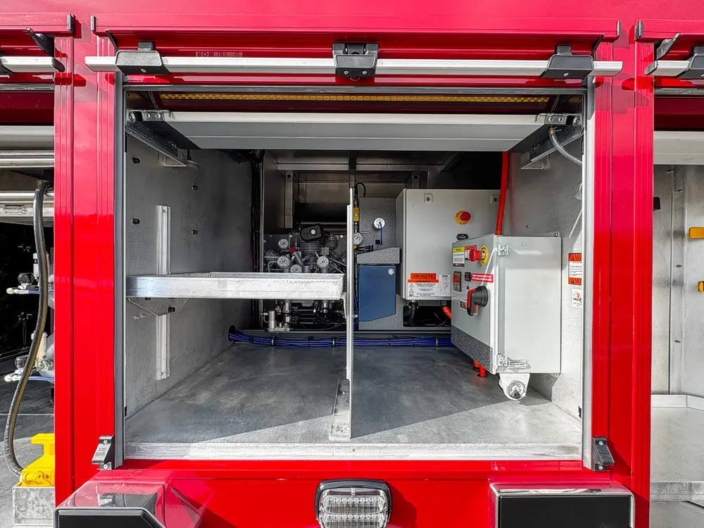 Open equipment compartment with electrical and compressor support components.