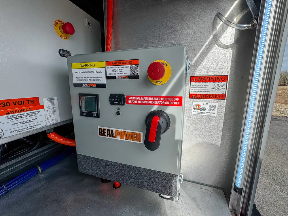 Detail of gray Real Power control box with warning labels.