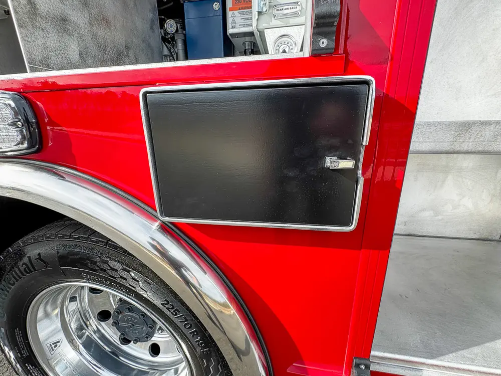 Closed rectangular side access panel above rear wheel area.