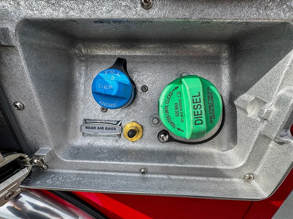 Close detail of DEF and diesel fill points inside access panel.