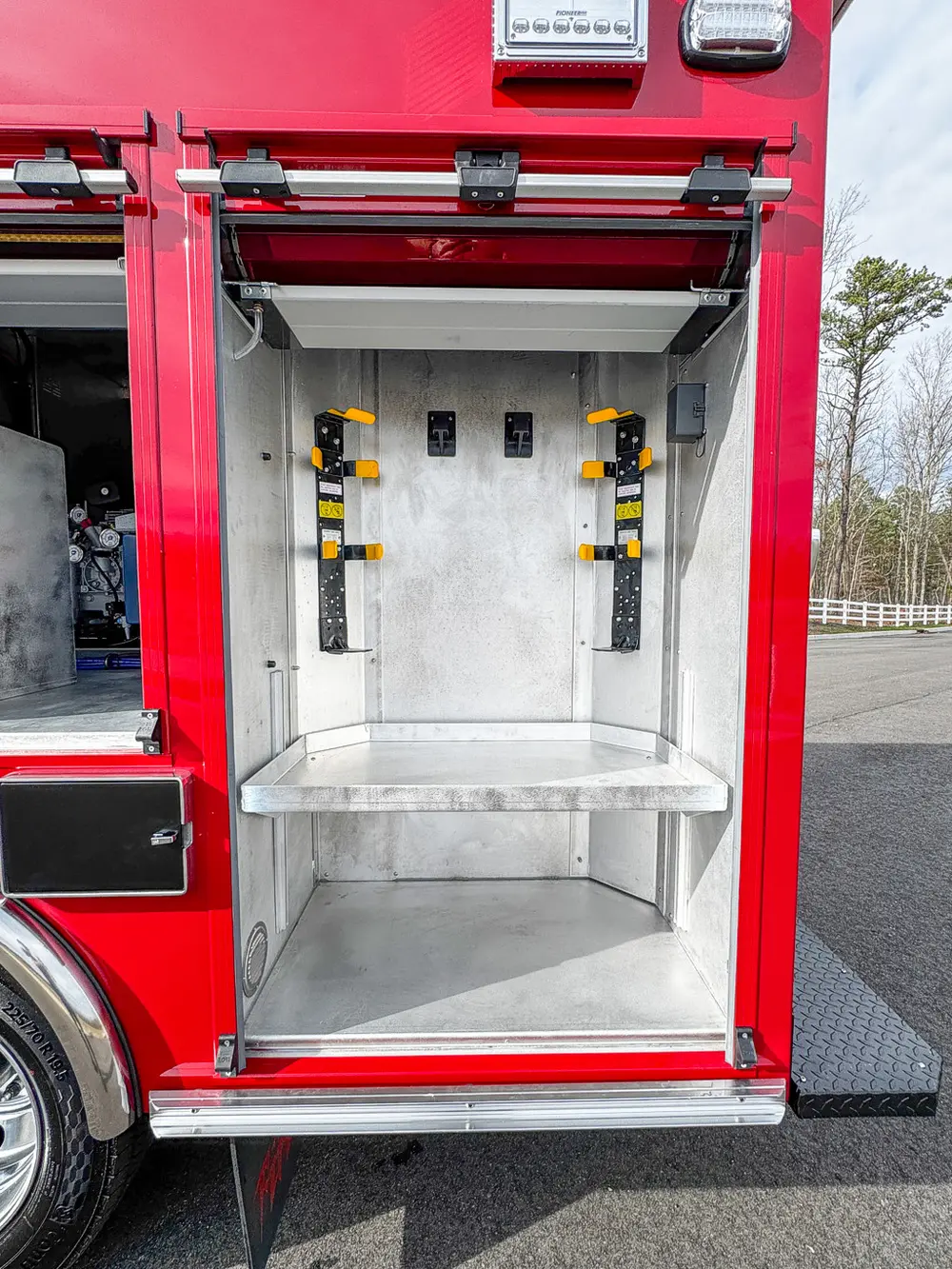 Vertical rear-side compartment with mounted brackets and shelf.