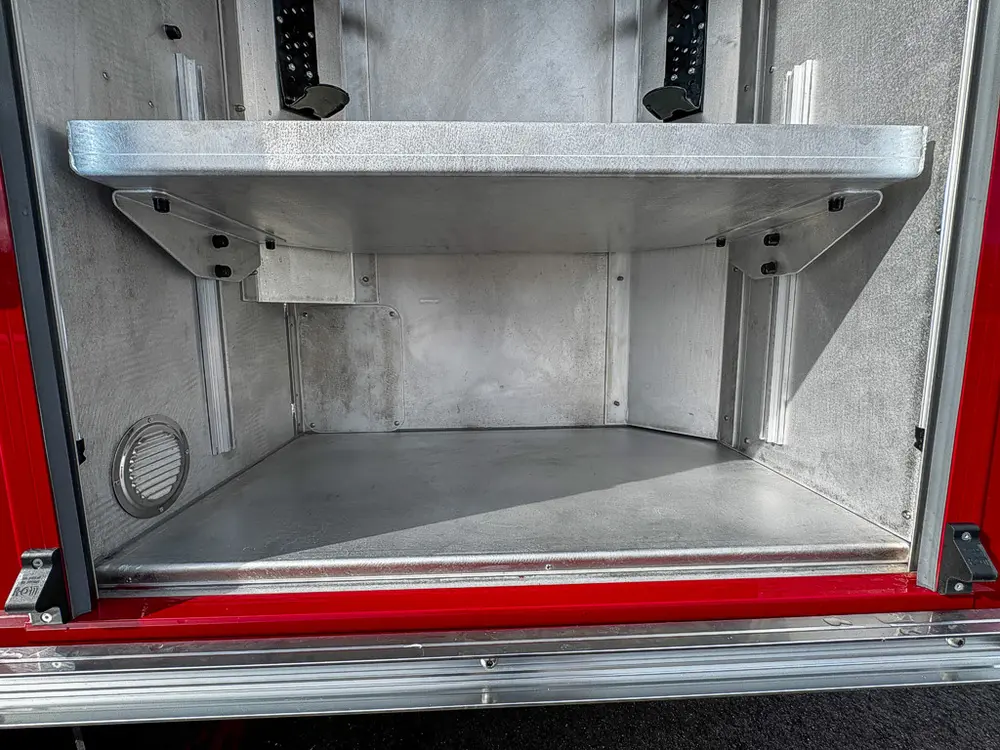 Lower shelf area inside tall rear-side compartment.