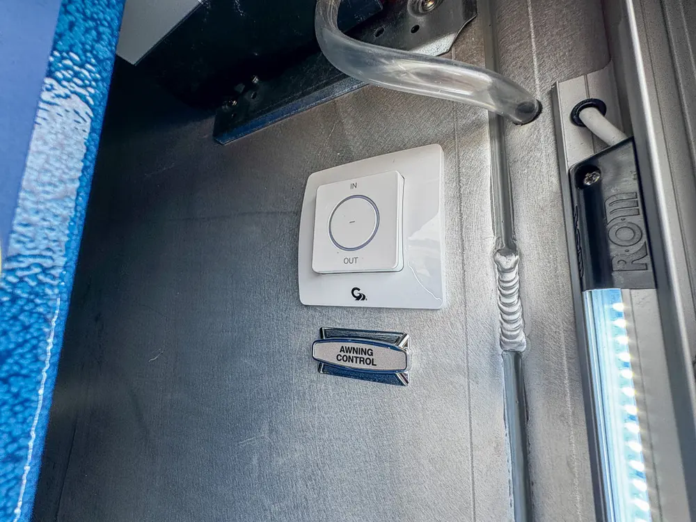 Exterior view of small fire truck showing cab, body compartments, and wheel/tire area.