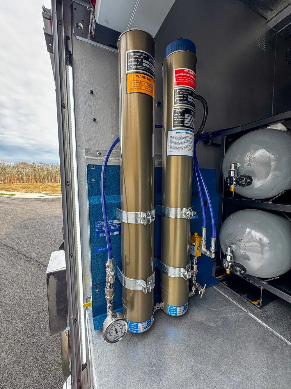 Exterior view of small fire truck showing cab, body compartments, and wheel/tire area.