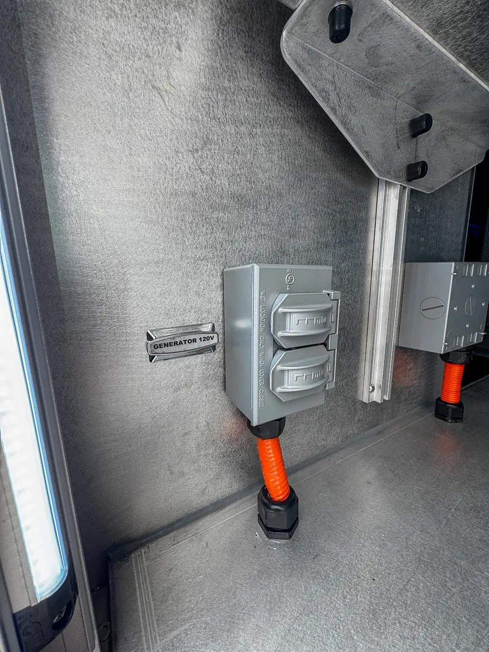 Exterior view of small fire truck showing cab, body compartments, and wheel/tire area.